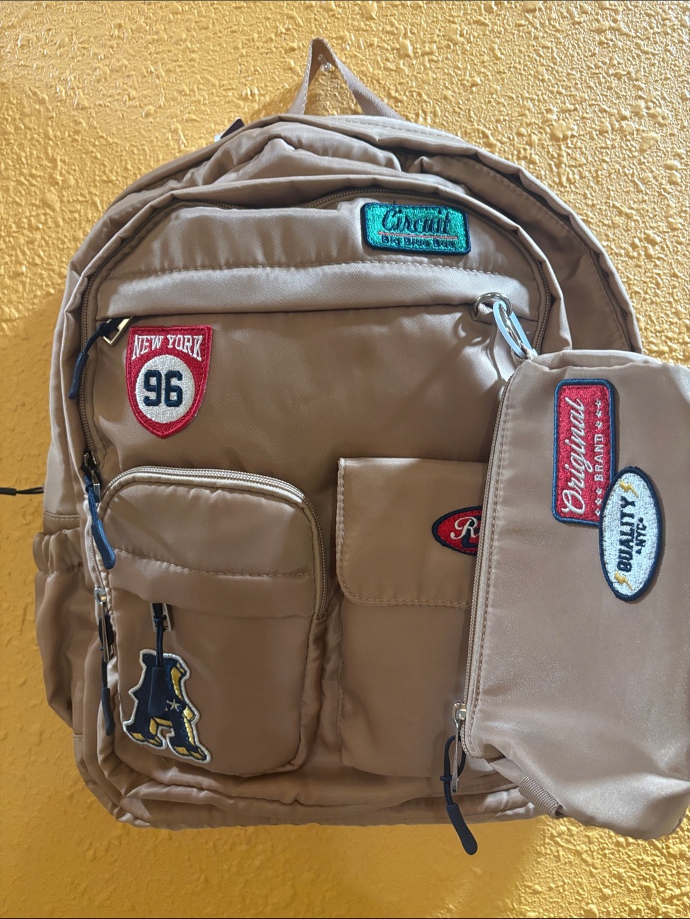 Beige Men's Backpack with Patch Accents and Matching Pouch